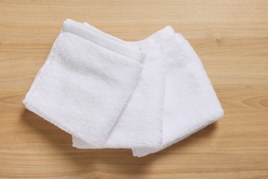 Photo of Soft folded terry towels on wooden table, top view