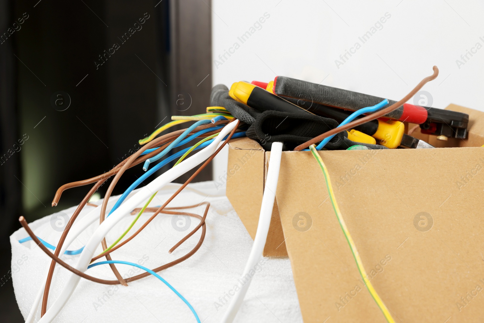 Photo of Different tools and cables in paper indoors. Installation of electrical wiring