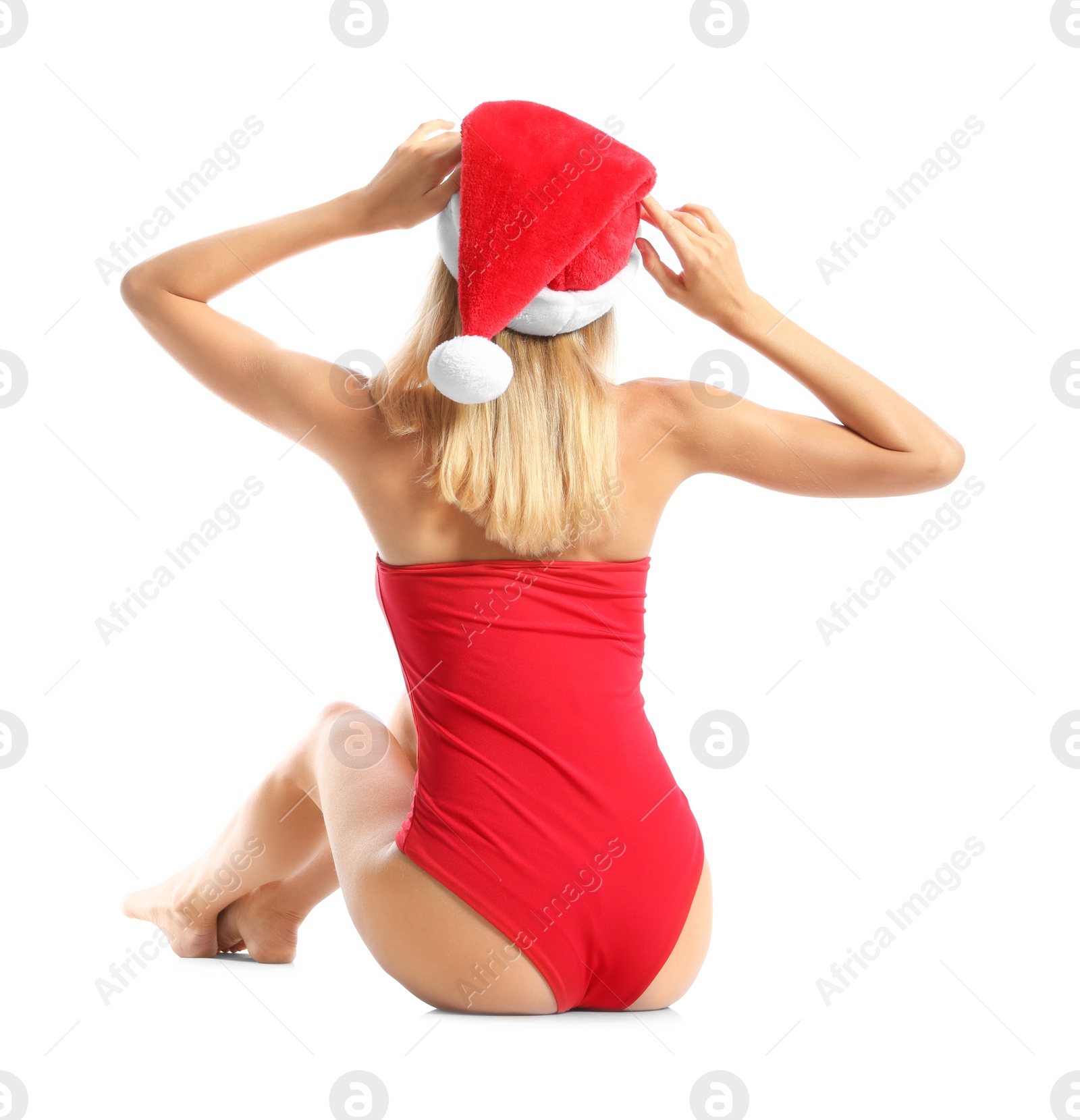 Photo of Young woman wearing Santa Claus hat on white background, back view. Christmas vacation