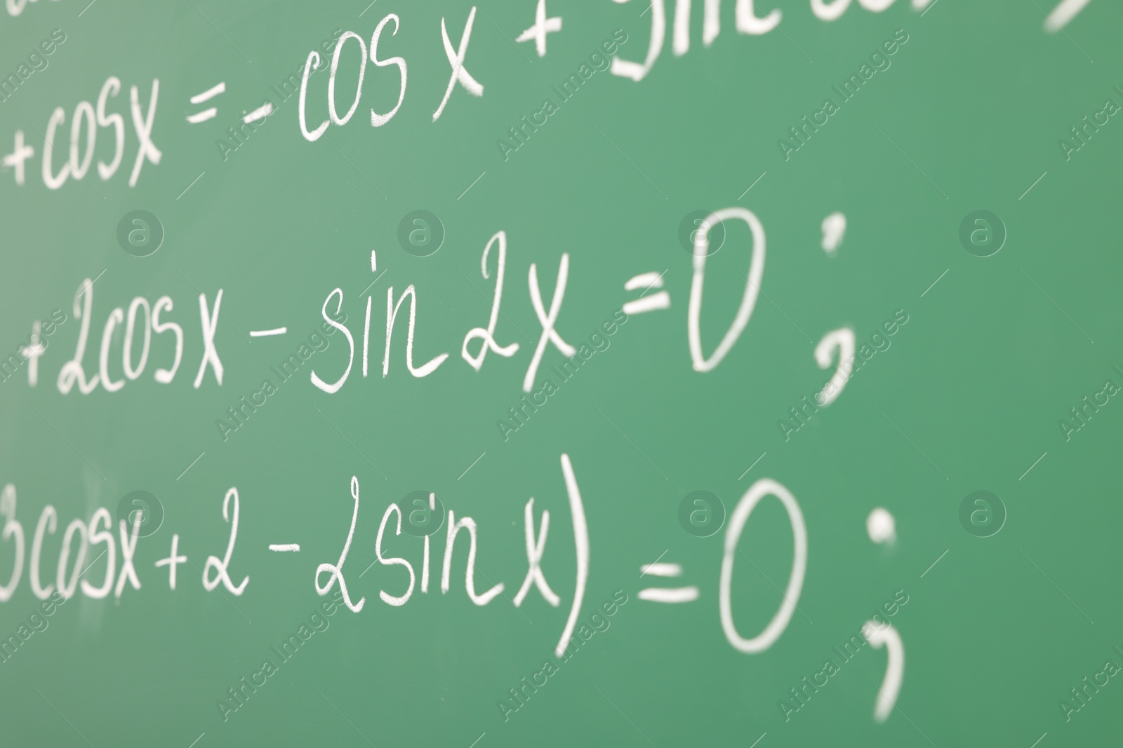 Photo of Many different math formulas written on green chalkboard, closeup
