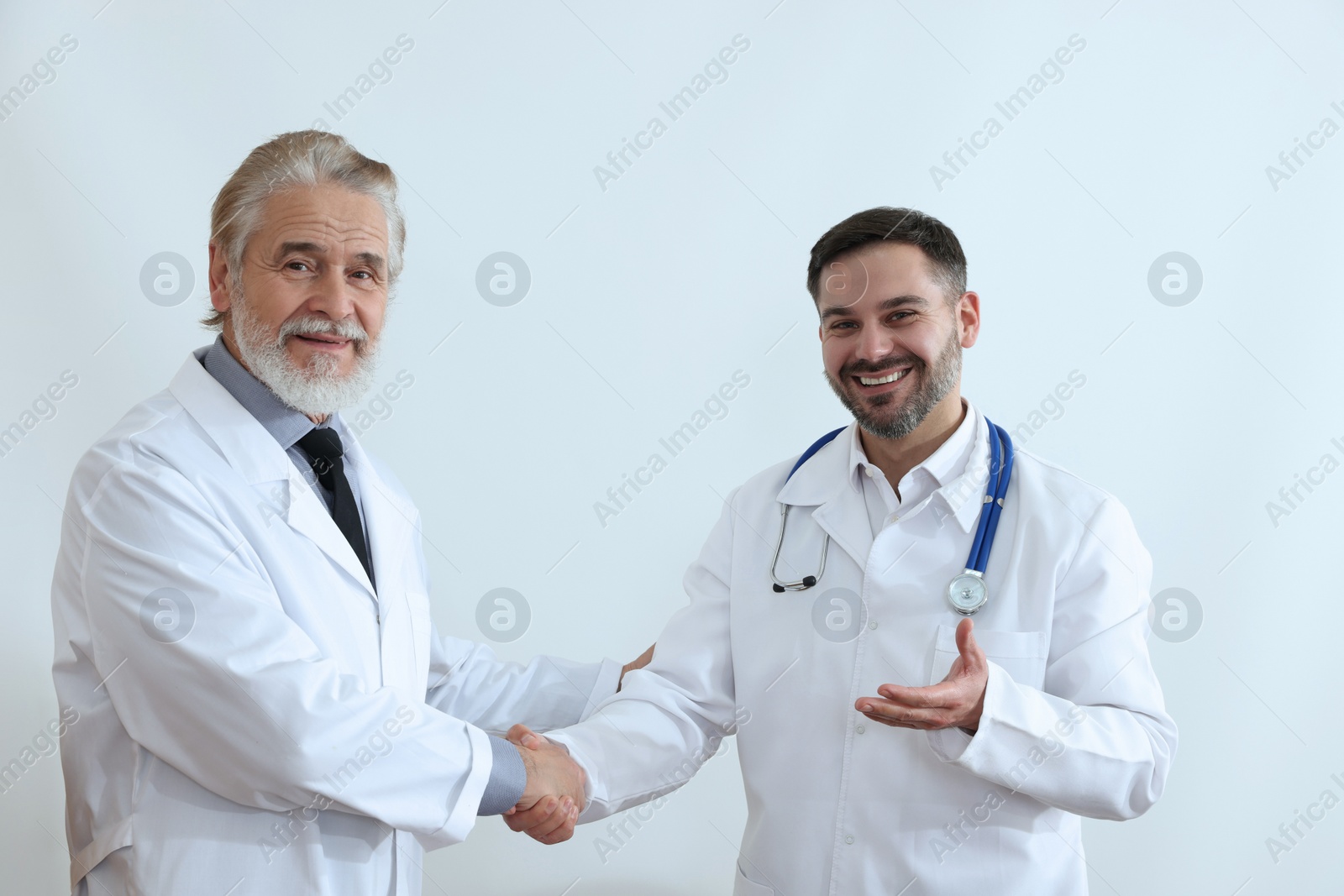 Photo of Doctors shaking hands on white background. Medical conference