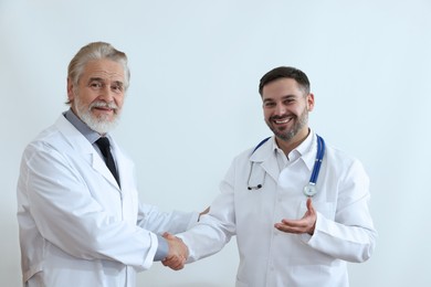 Photo of Doctors shaking hands on white background. Medical conference