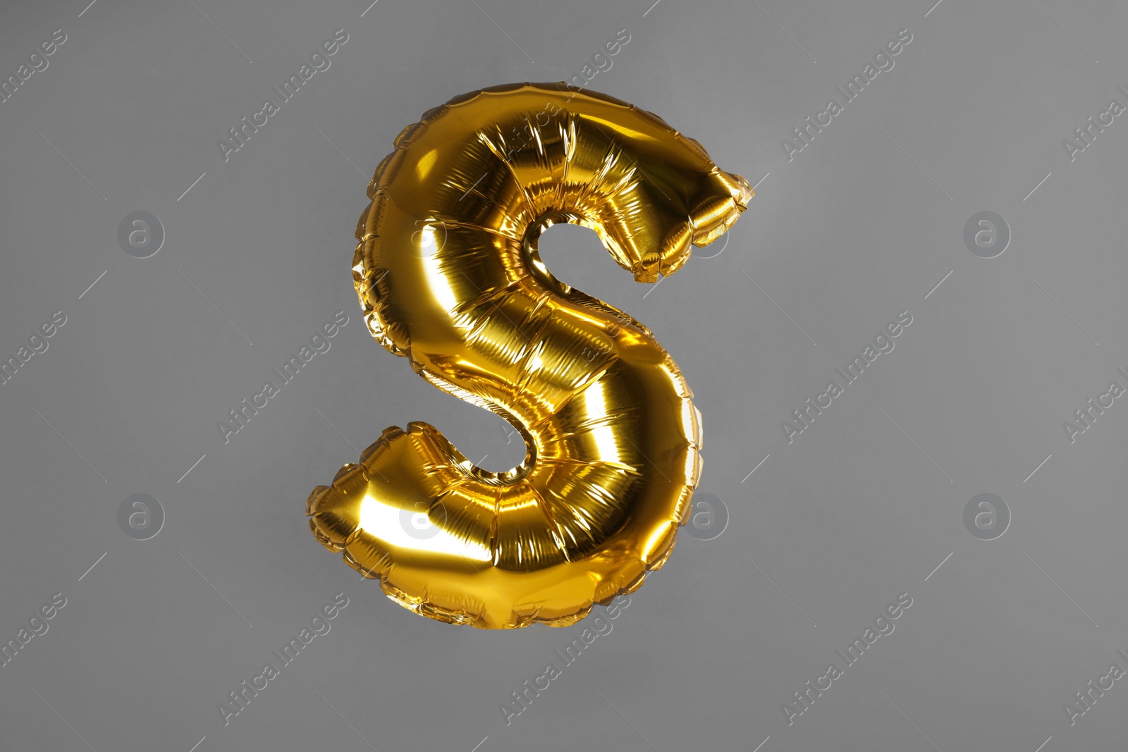 Photo of Golden letter S balloon on grey background