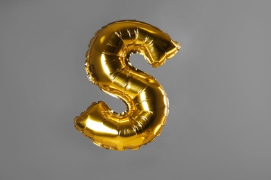 Golden letter S balloon on grey background