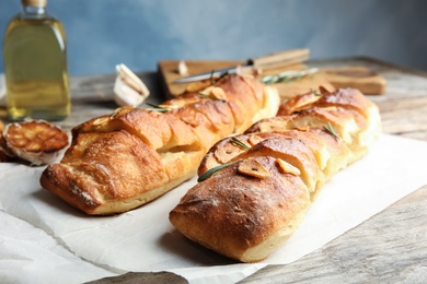 Delicious homemade garlic bread with rosemary on table