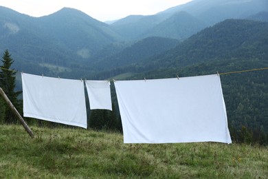 Photo of Bedclothes hanging on washing line in mountains