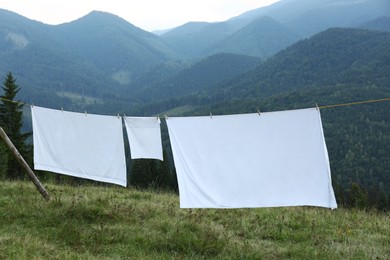 Bedclothes hanging on washing line in mountains