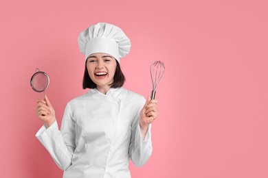 Happy confectioner with sieve and whisk on pink background, space for text