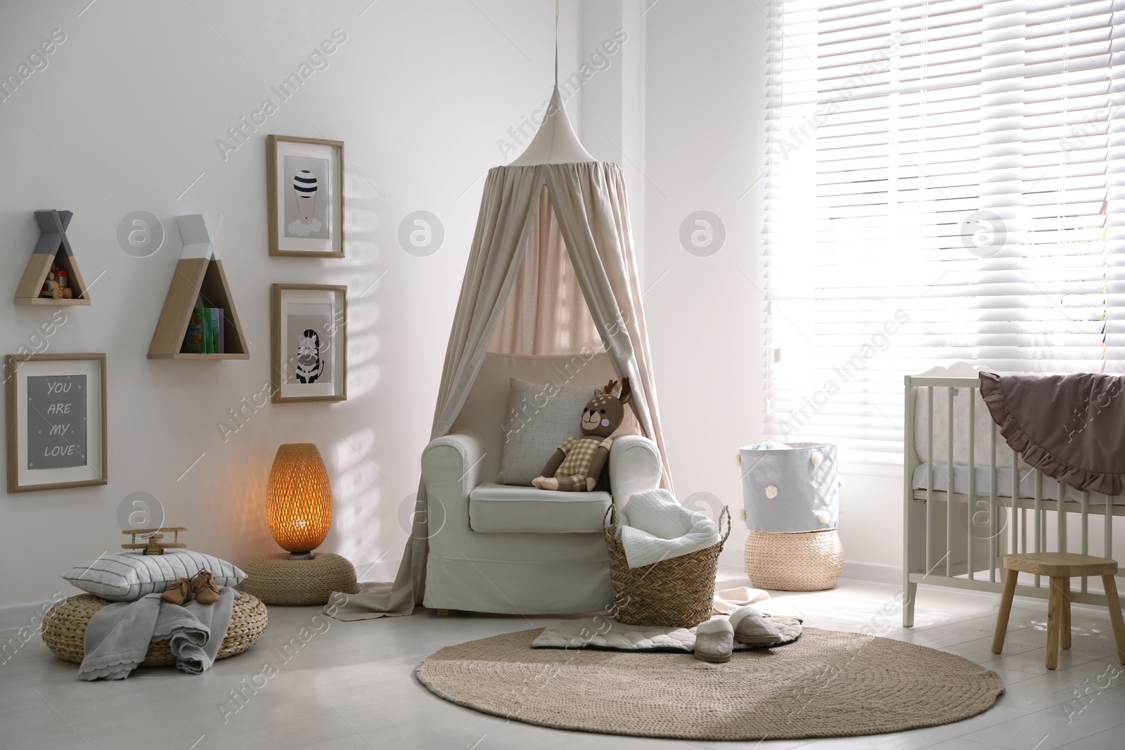 Photo of Stylish baby room interior with crib and comfortable armchair