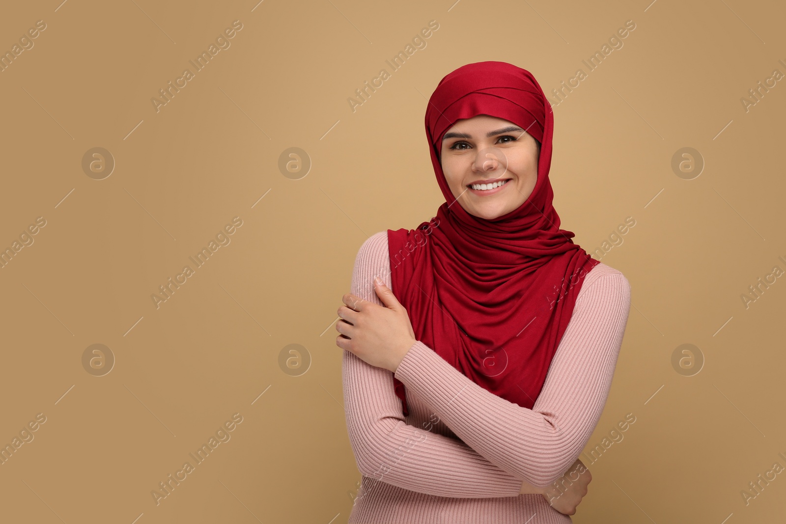 Photo of Portrait of Muslim woman in hijab on beige background, space for text