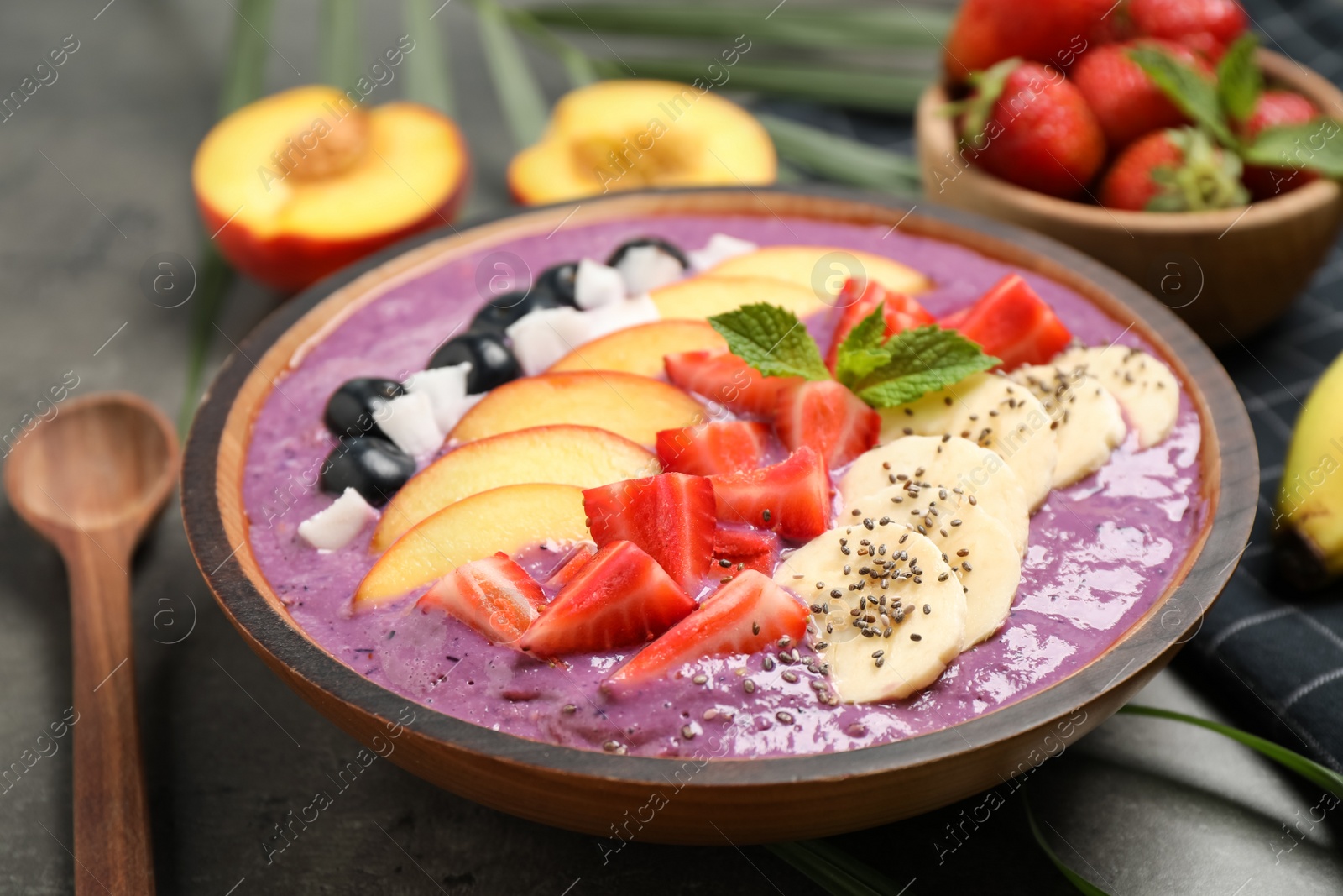 Photo of Delicious acai smoothie with fresh fruits on table, closeup