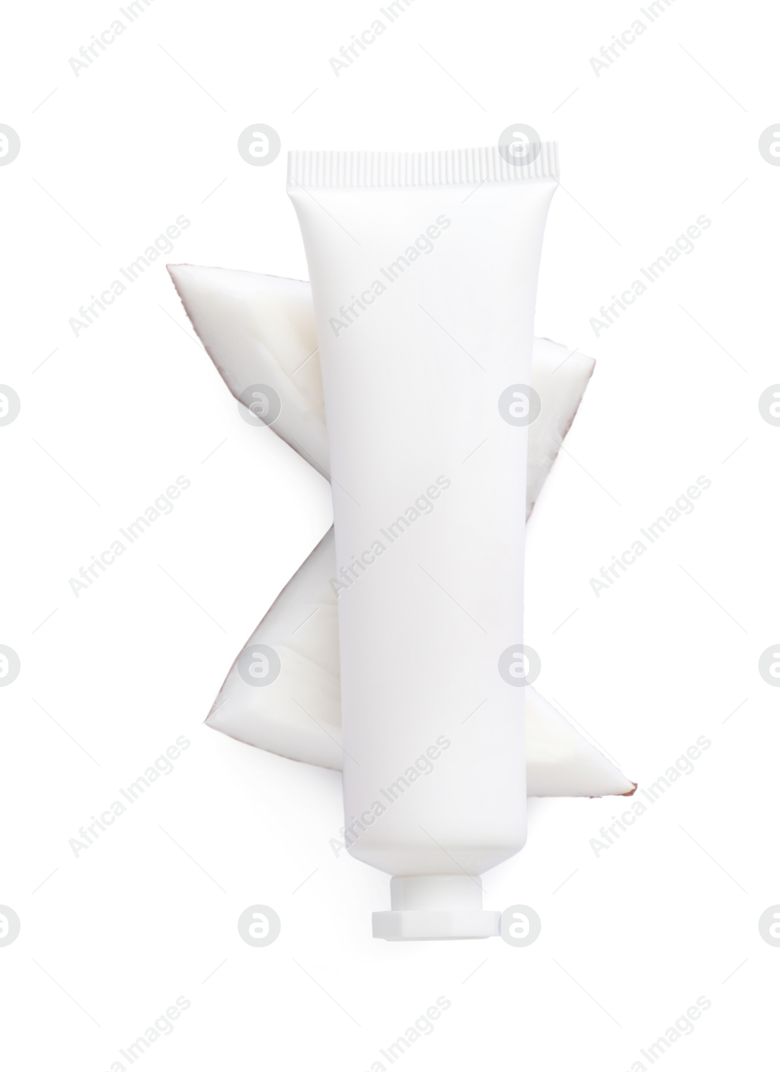 Photo of Tube of hand cream and coconut pieces on white background, top view