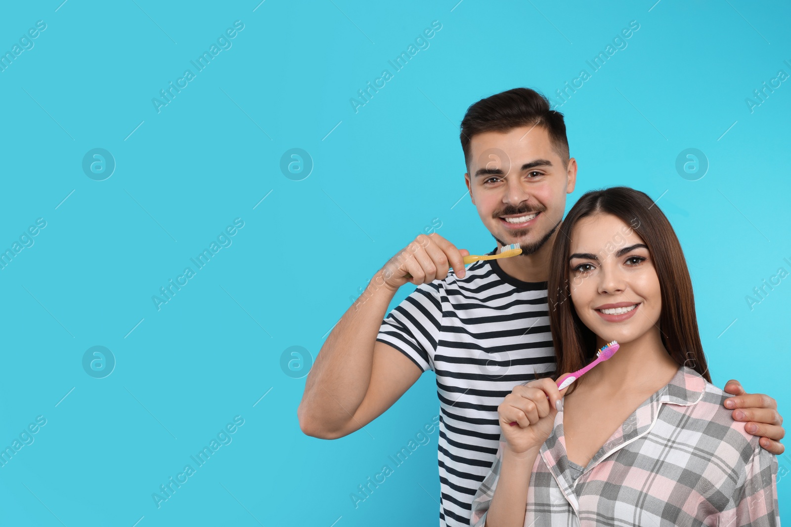 Photo of Happy couple brushing teeth on color background. Space for text