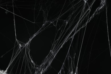 Photo of Creepy white spider web on black background