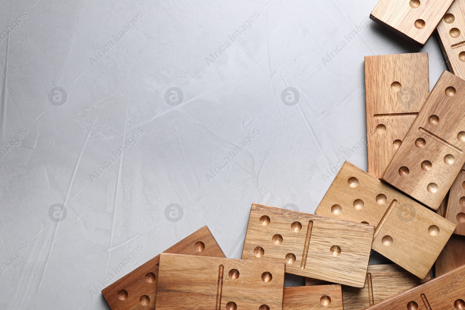 Photo of Wooden domino tiles on grey table, flat lay. Space for text