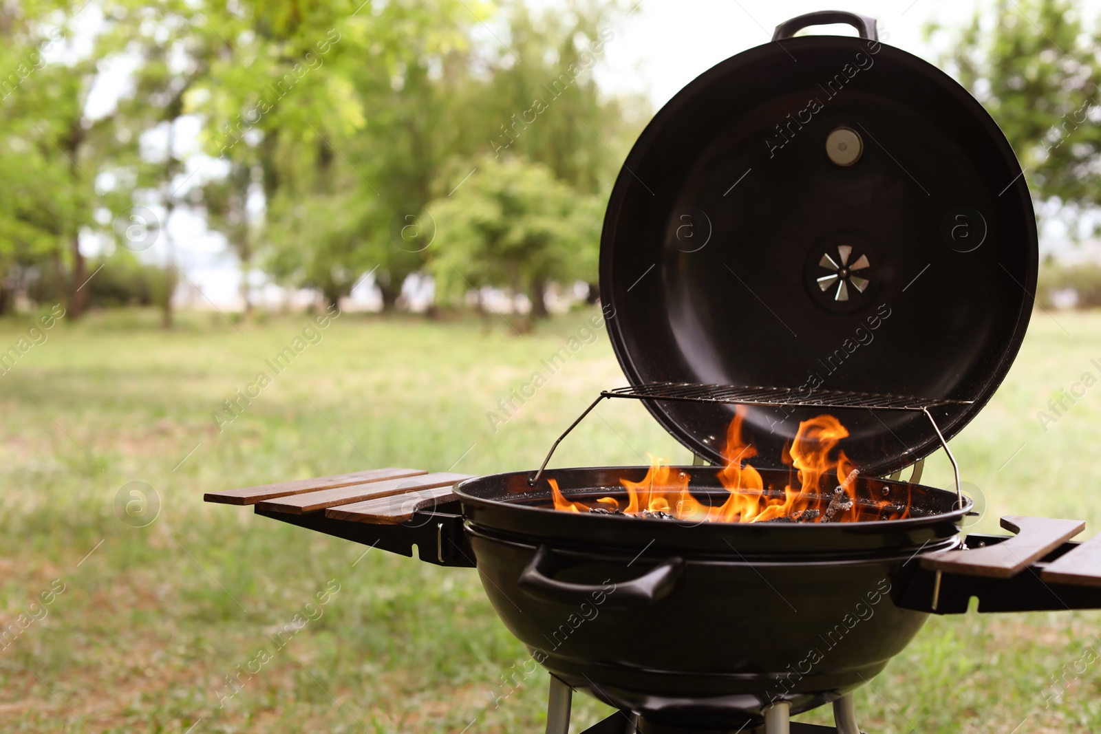 Photo of Modern barbecue grill with fire flames outdoors