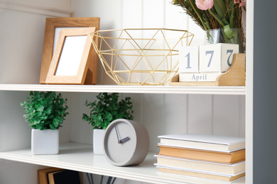 White shelving unit with plants and different decorative stuff