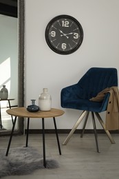 Room with wooden table and blue armchair. Stylish interior