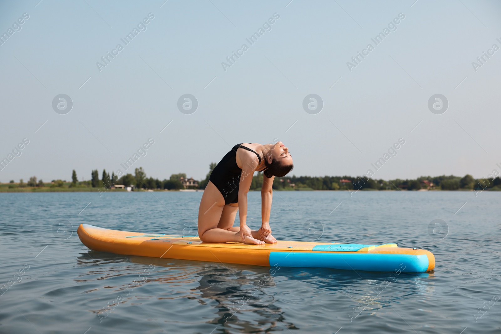 Photo of Woman practicing yoga on SUP board on river