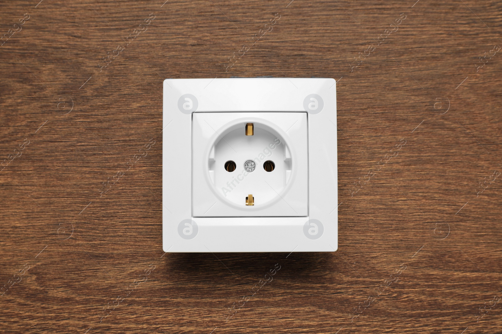 Photo of Modern plastic power socket on wooden table, top view