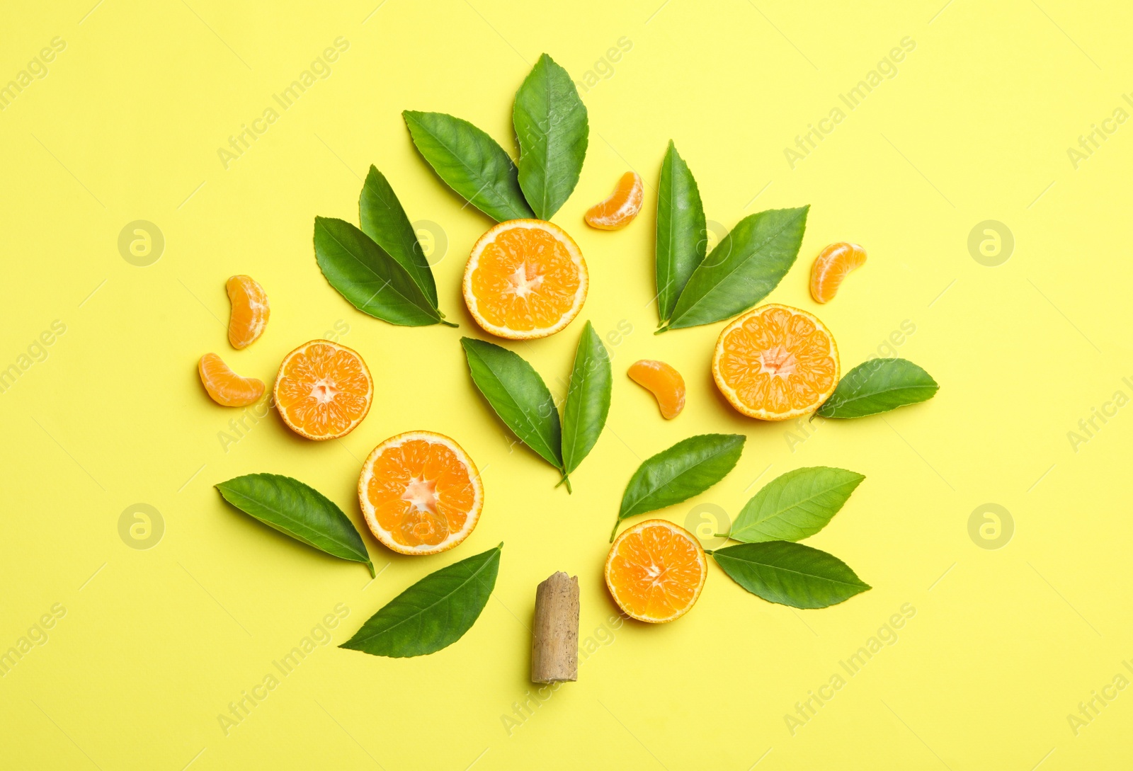 Photo of Flat lay composition with fresh green citrus leaves and tangerine slices on yellow background