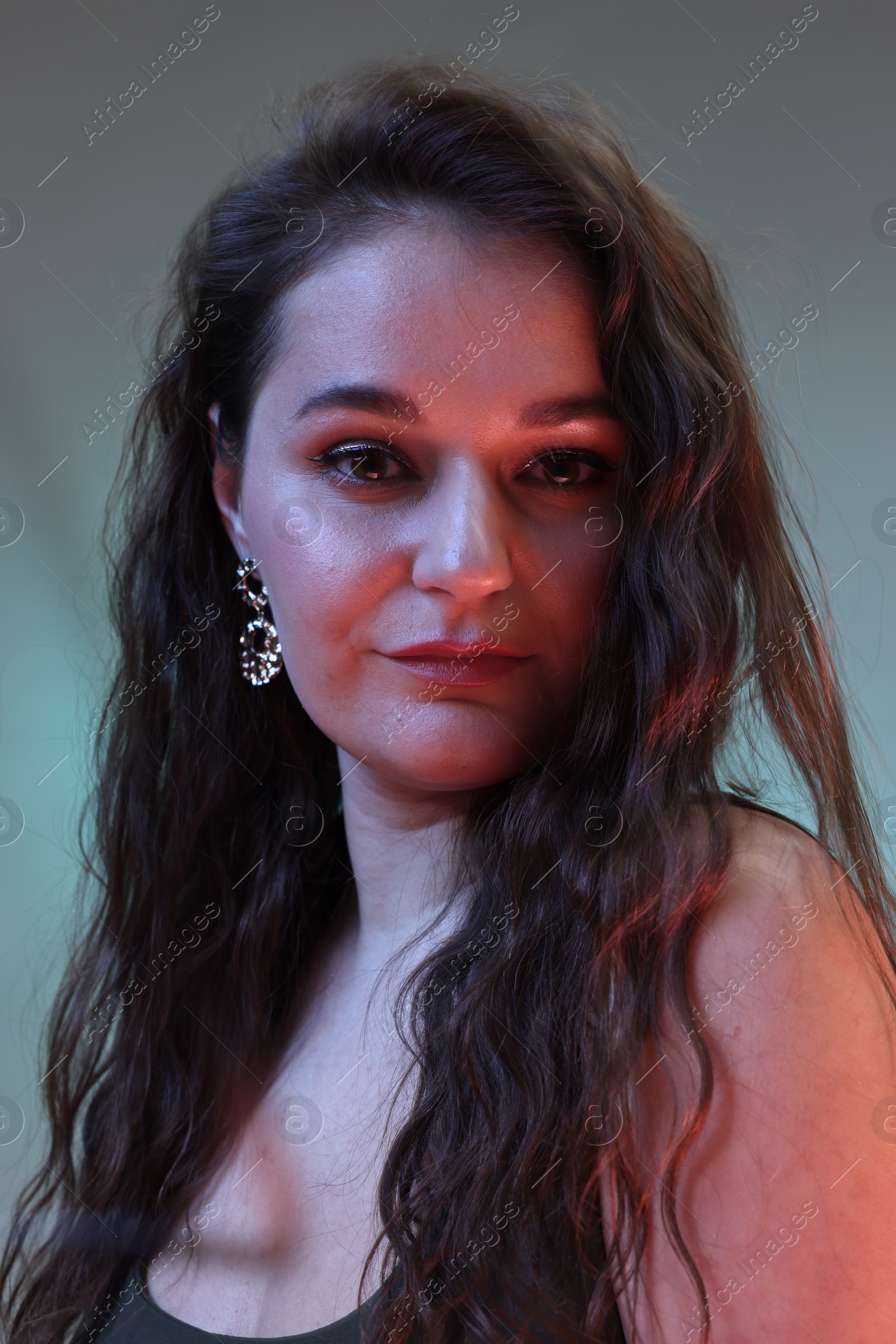 Photo of Portrait of beautiful woman on color background with neon lights