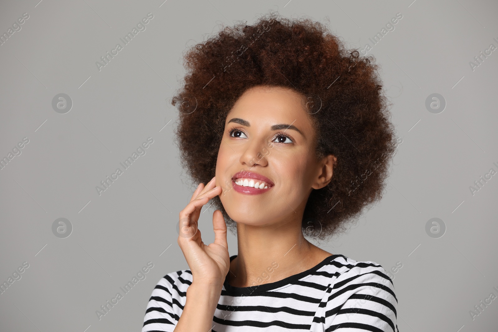 Photo of Portrait of beautiful young woman with glamorous makeup on grey background