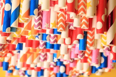 Photo of Many paper drinking straws on yellow background, closeup