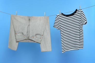 Photo of Clothes drying on laundry line against light blue background