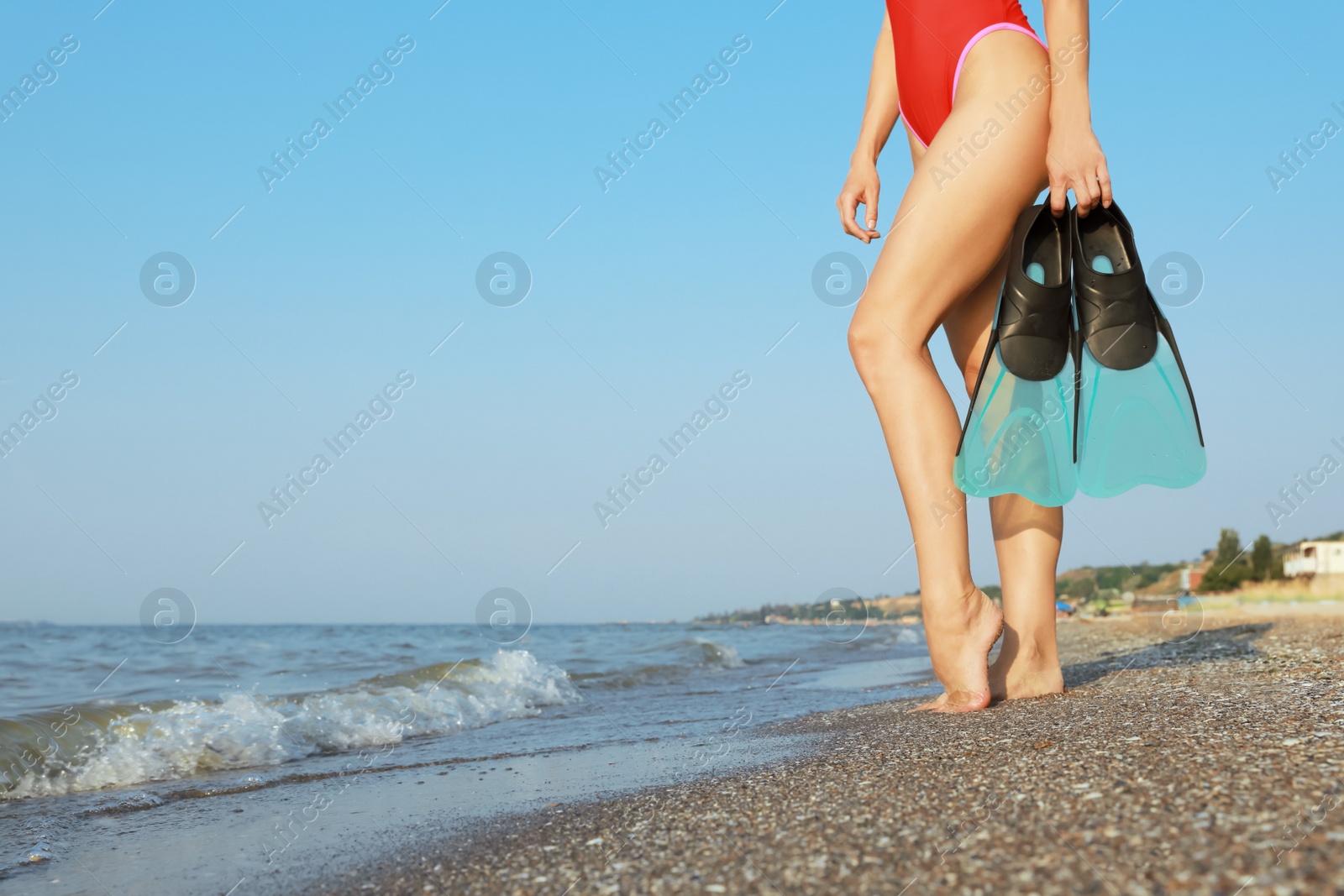 Photo of Woman with flippers near sea on beach, closeup