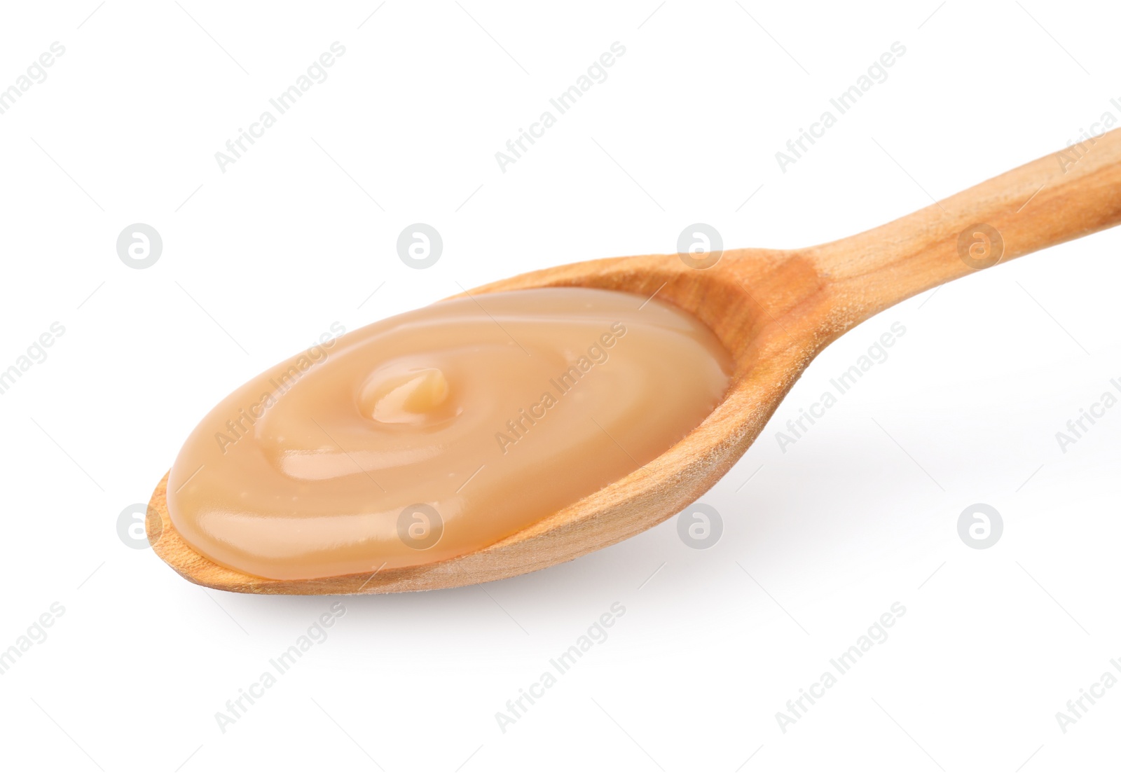 Photo of Wooden spoon with tasty salted caramel isolated on white