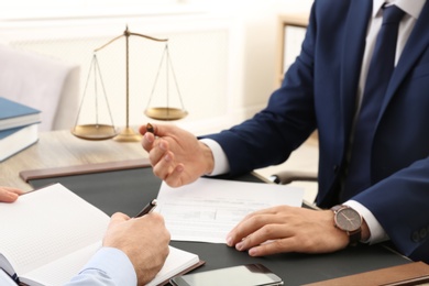 Photo of Lawyer working with client at table in office, focus on hands