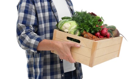 Photo of Harvesting season. Farmer holding wooden crate with vegetables on white background, closeup