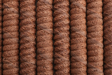 Delicious chocolate wafer rolls as background, top view. Sweet food