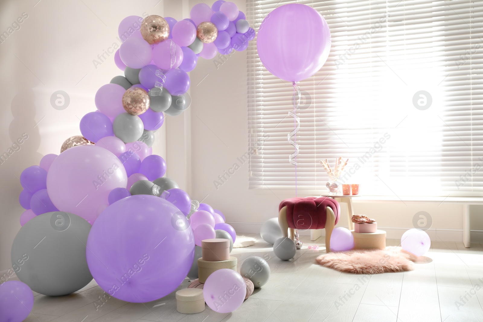 Image of Balloon garland near white wall in room. Festive decor