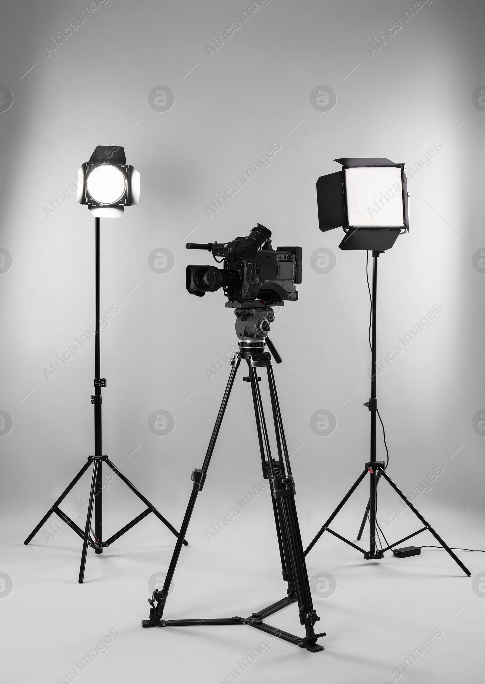 Photo of Professional video camera and lighting equipment on white background