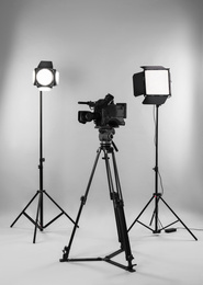 Professional video camera and lighting equipment on white background