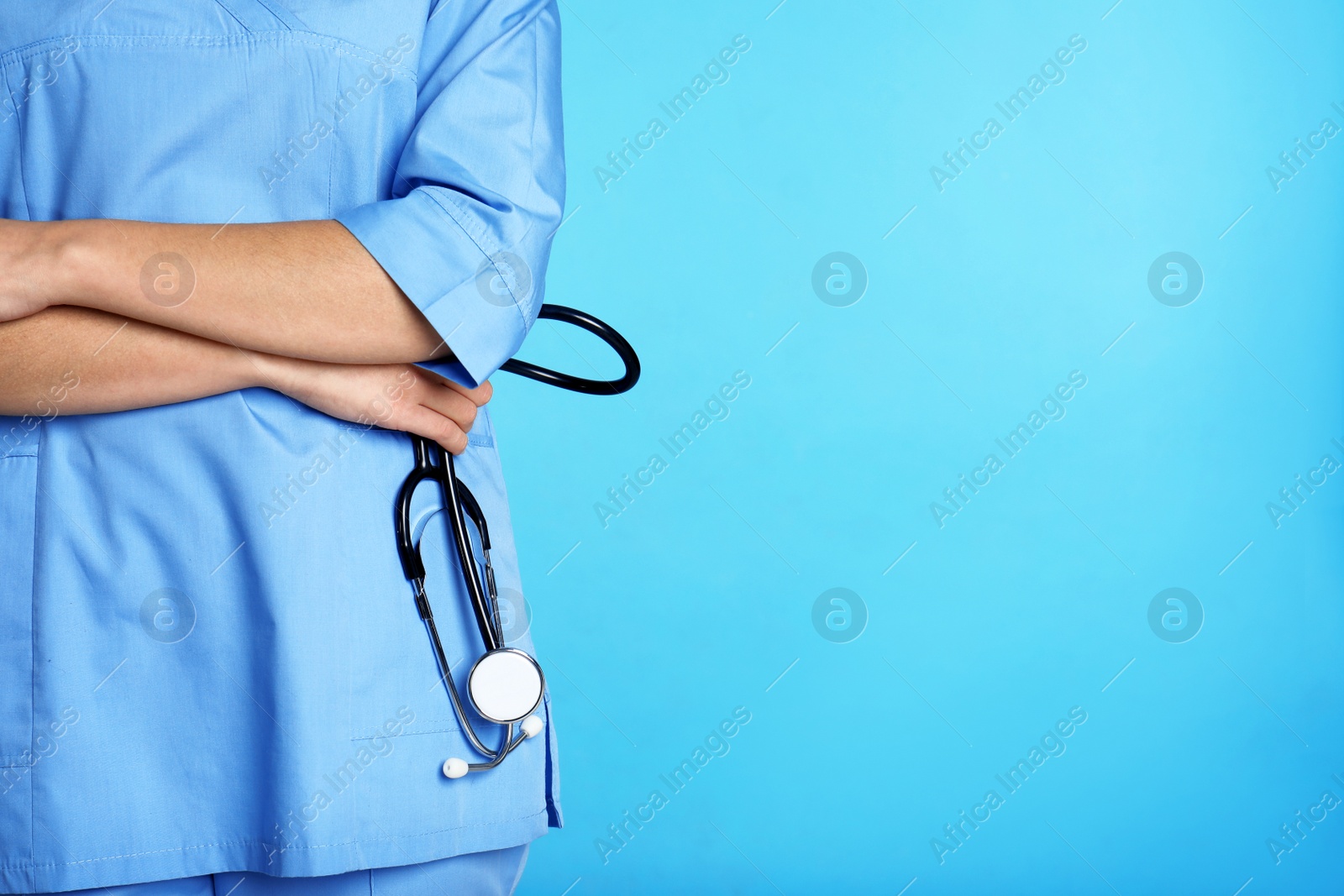 Photo of Medical assistant with stethoscope on color background. Space for text