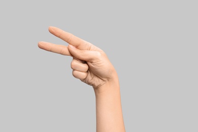 Photo of Woman showing P letter on grey background, closeup. Sign language