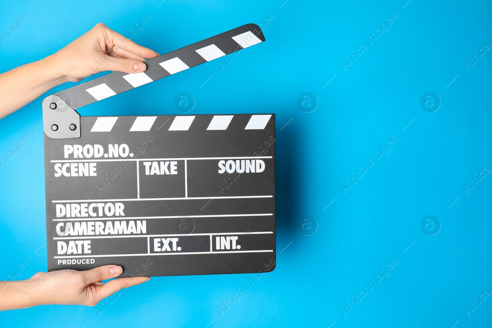 Photo of Woman holding clapperboard on color background, closeup with space for text. Cinema production