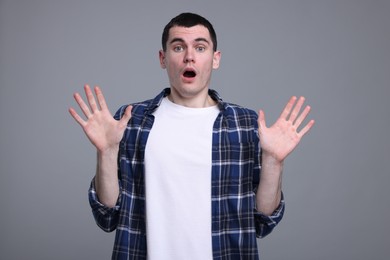 Portrait of surprised man on grey background