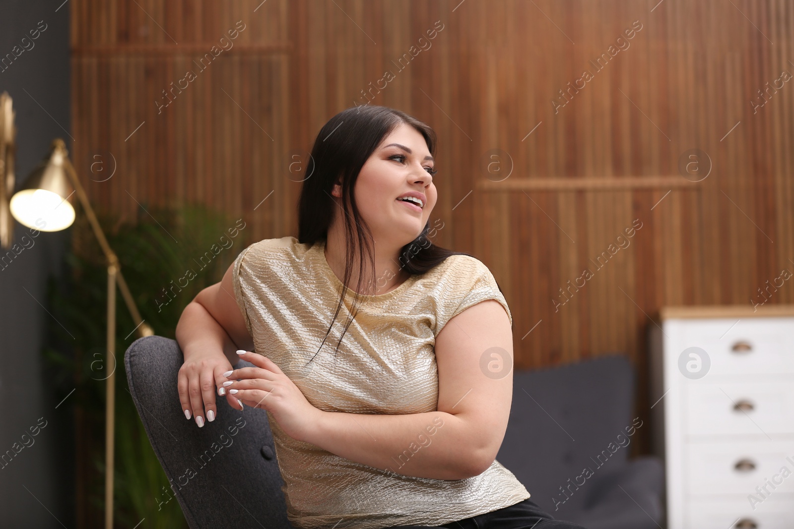 Photo of Beautiful overweight woman posing indoors. Plus size model