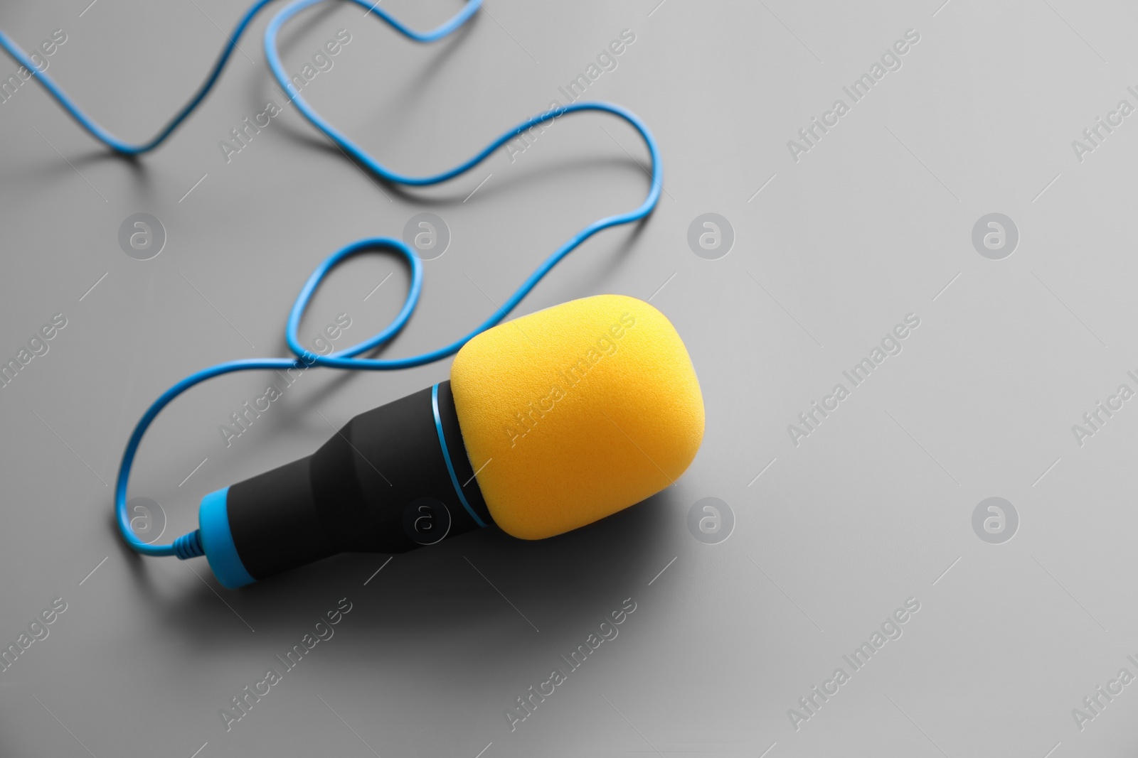 Photo of Microphone on light grey background. Journalist's work