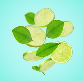 Image of Fresh lime slices and green leaves falling on light blue background