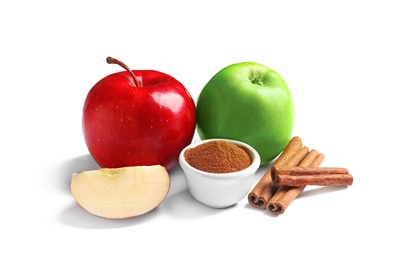 Photo of Fresh apples with cinnamon sticks and powder on white background