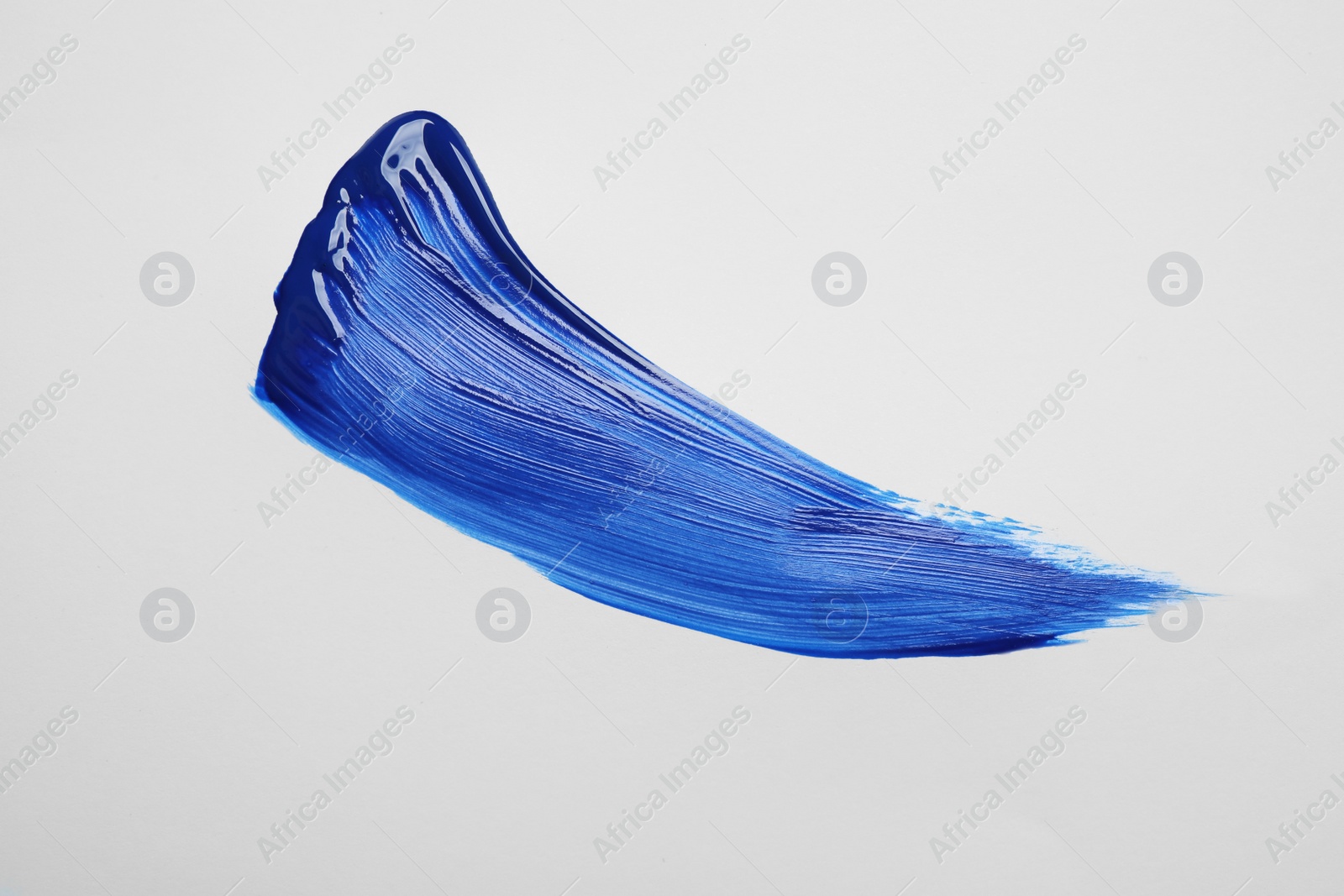 Photo of Paint stroke on white background background, top view. Color of the year 2020 (Classic blue)