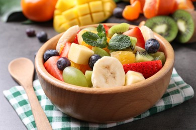 Photo of Delicious fresh fruit salad on grey table