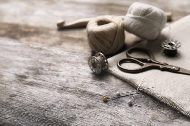Composition with threads and sewing accessories on wooden background