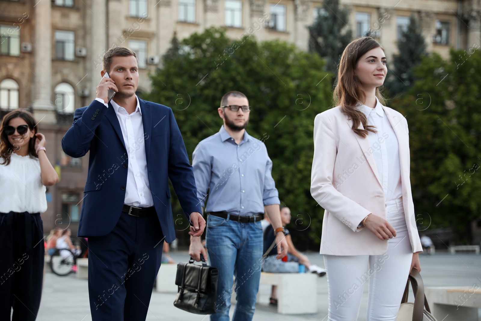 Photo of Different people walking on modern city street