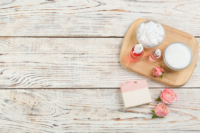 Flat lay composition with natural handmade soap and ingredients on white wooden table, space for text